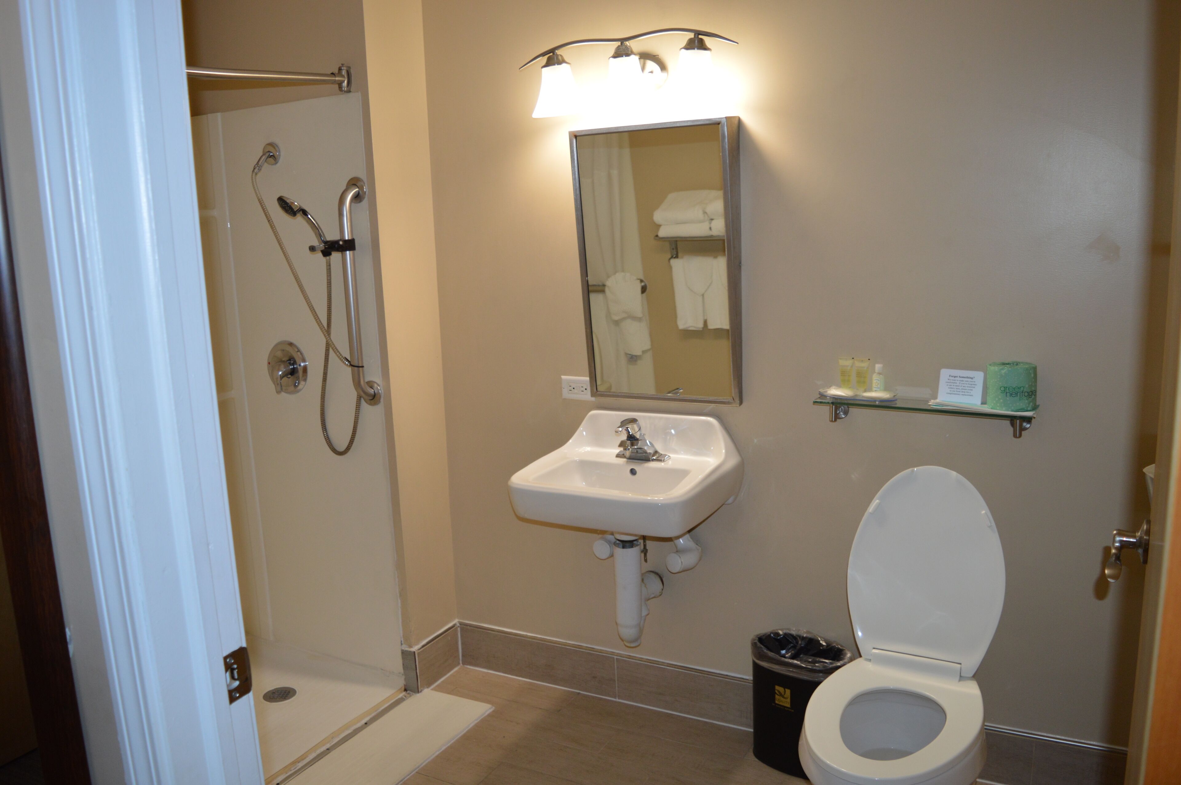 A bathroom with a shower, sink, and toilet.
