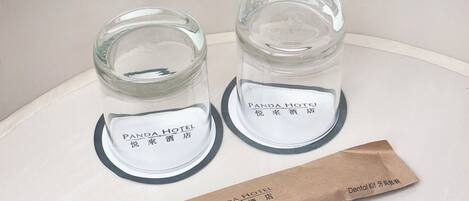 Two glass jars with labels, a brown paper bag, and a white paper with text.