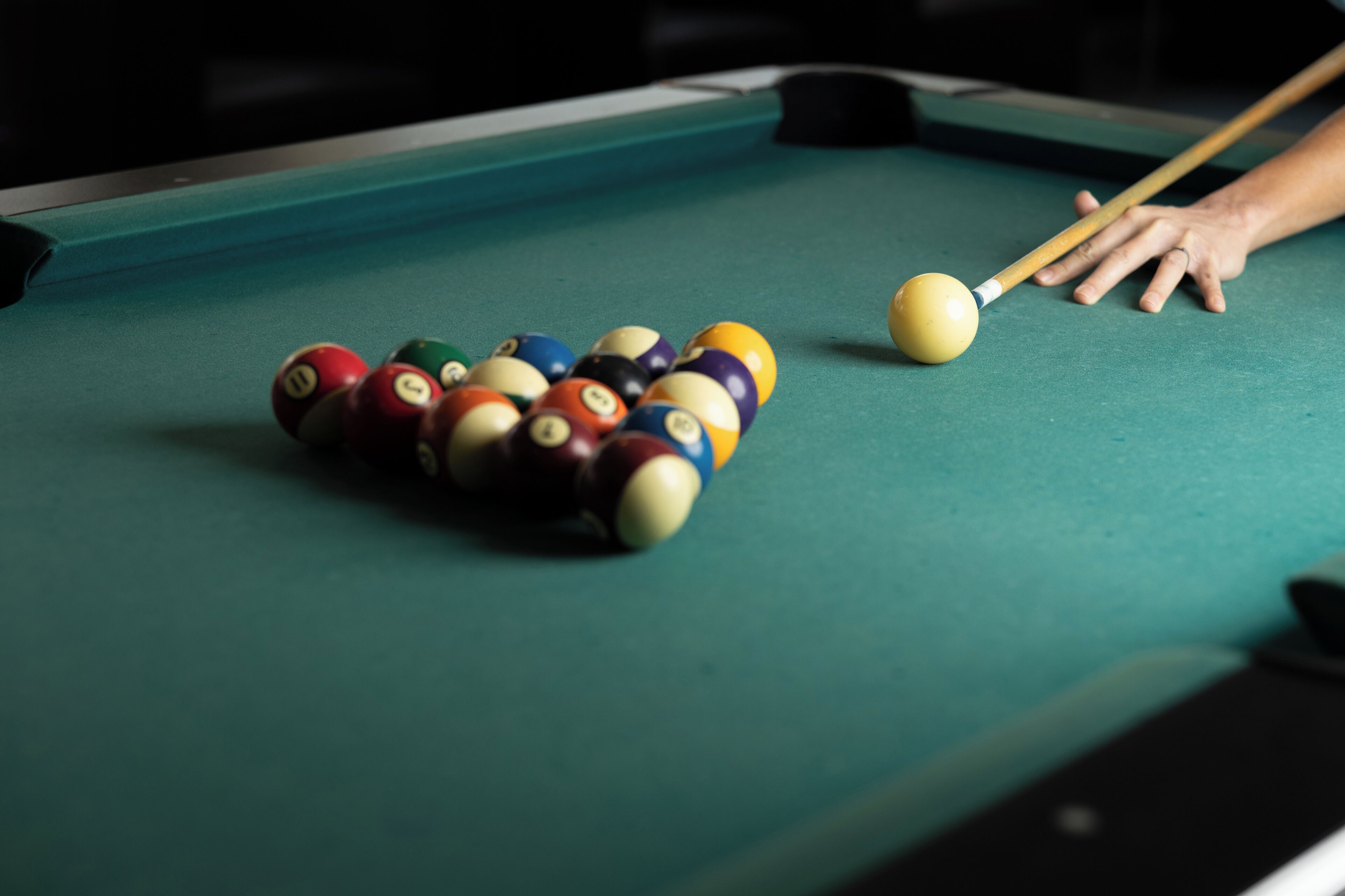 A pool table with a cue ball and striped balls.