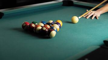 A pool table with a cue ball and striped balls.