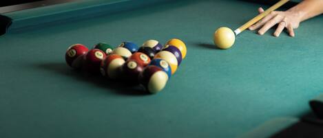 A pool table with a cue ball and striped balls.
