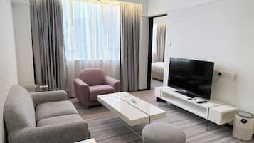 Deluxe suite, 1 queensize bed | Woonruimte | Een 32-inch televisie met satellietzenders