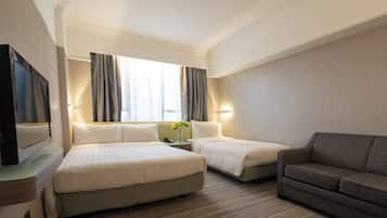 A hotel room with two beds, a TV, a sofa, and a window with curtains.