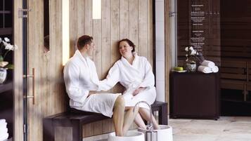Una pareja en un entorno de spa, con paneles de madera y un banco.