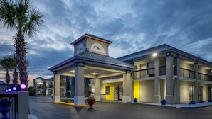 A hotel with a central entrance, multiple balconies, and a parking area. - Baymont by Wyndham Covington (Covington)