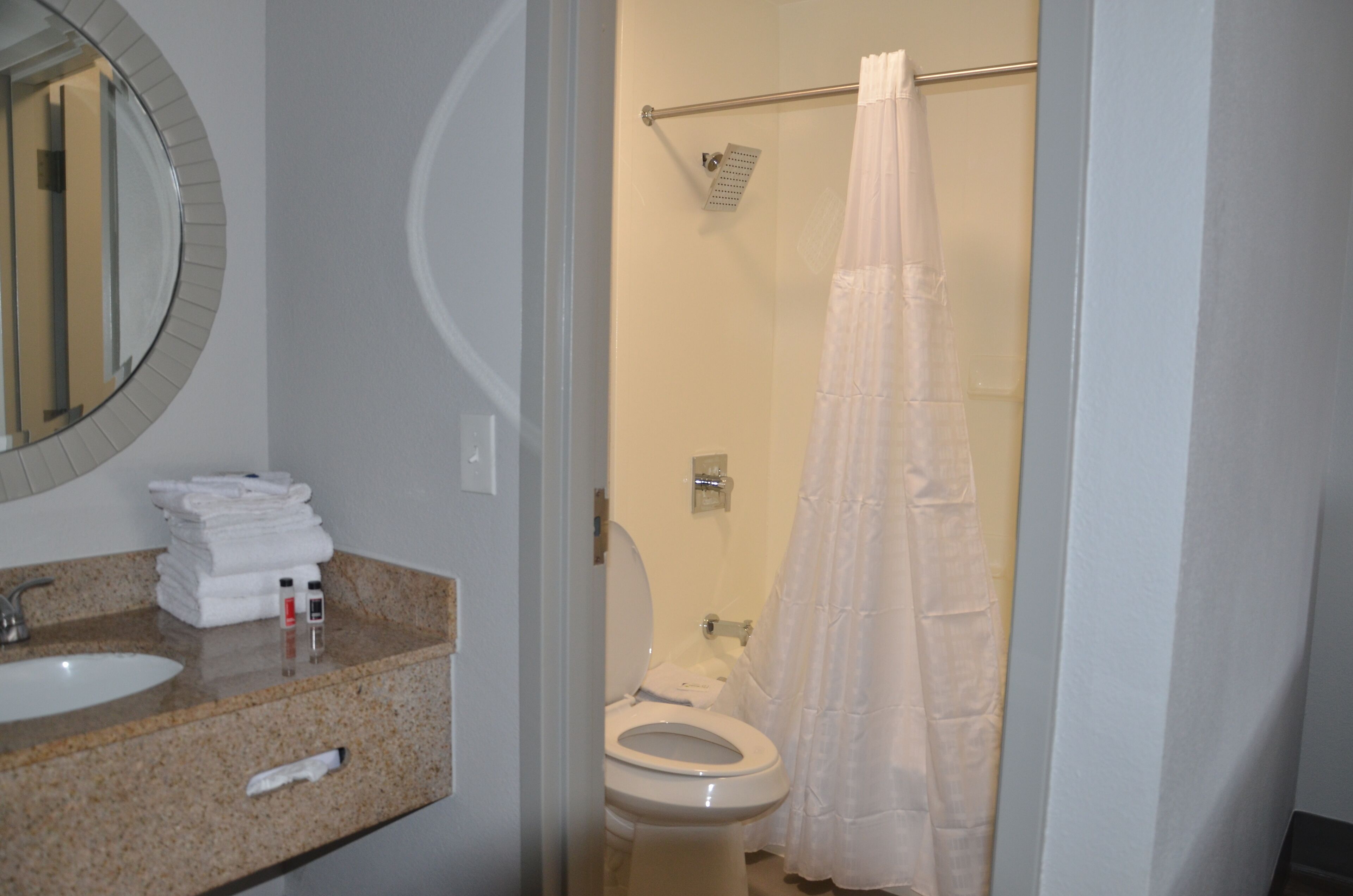 A bathroom with a sink, toilet, and shower curtain.