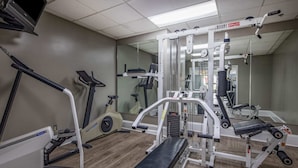 A gym with cardio machines, weightlifting equipment, and a mirrored wall. - Baymont by Wyndham Covington (Covington)