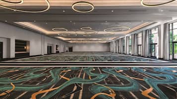 A spacious conference room with a patterned carpet, large windows, and circular ceiling lights.