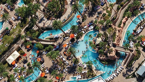 An aerial view of a resort with multiple swimming pools, palm trees, and sun loungers. - MGM Grand Hotel & Casino (Las Vegas)