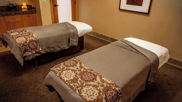 Dos camas individuales con cubrecamas estampados en una habitación de hotel.