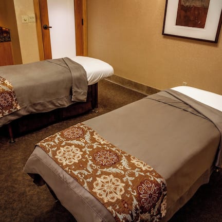 Dos camas individuales con cubrecamas estampados en una habitación de hotel.