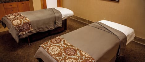 Dos camas individuales con cubrecamas estampados en una habitación de hotel.