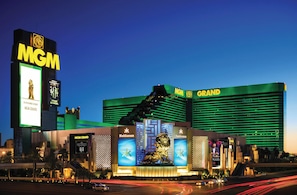 Un gran hotel con un llamativo cartel de MGM, varios balcones y una estatua central.
