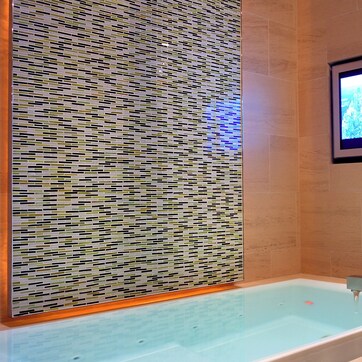 A modern bathroom with a large bathtub, a wall-mounted TV, and a decorative mosaic panel.