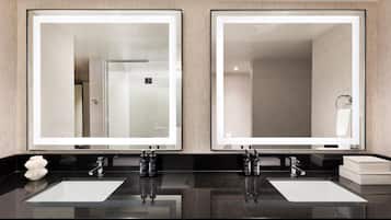 A modern bathroom with two sinks, large mirrors, and a black countertop.