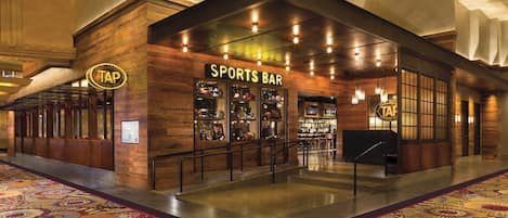 A sports bar with a wooden facade, bar seating, and a TAF sign.