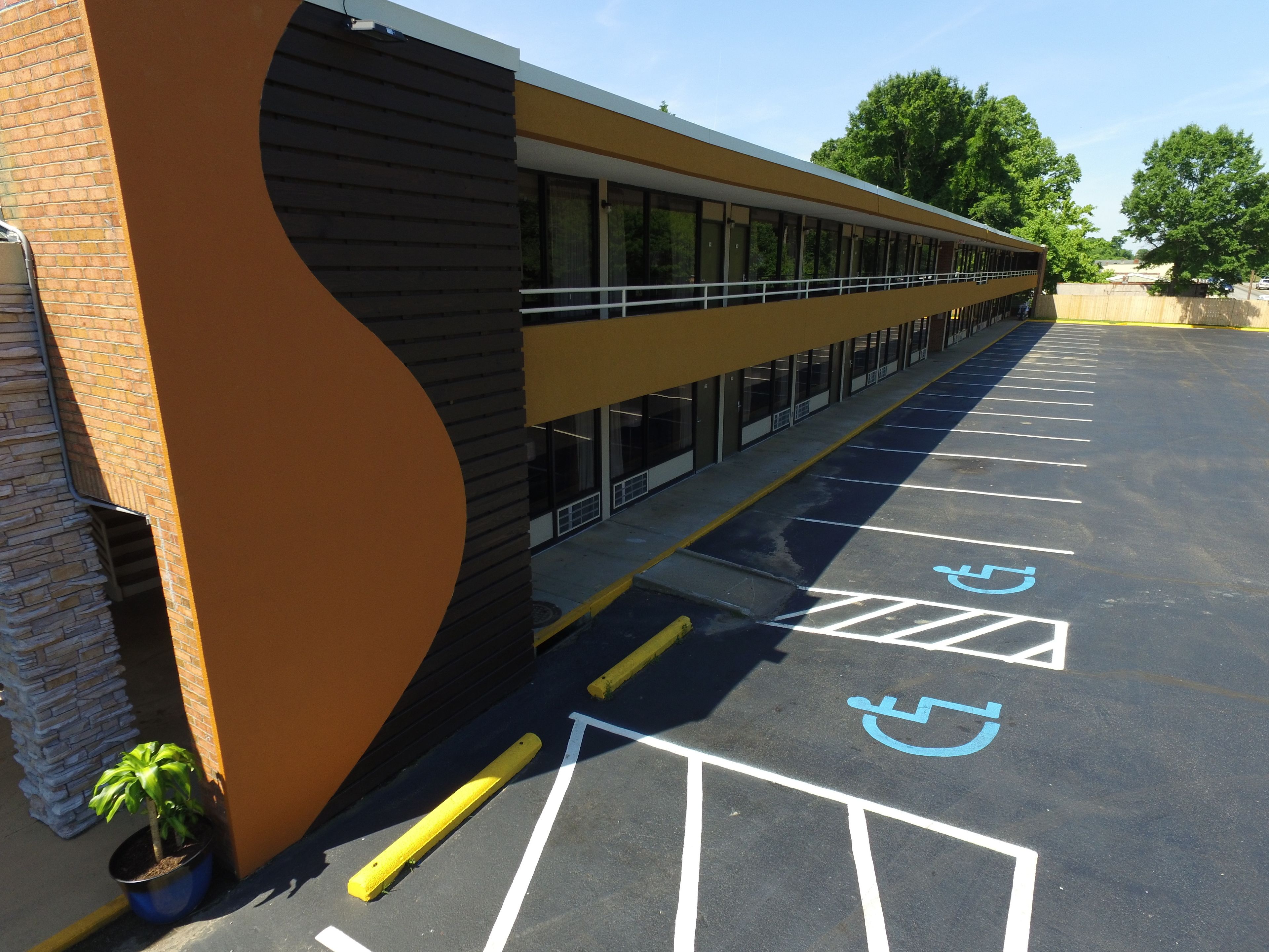 A parking lot with marked handicapped spaces and a building with a curved facade.