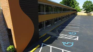 A parking lot with marked handicapped spaces and a building with a curved facade.