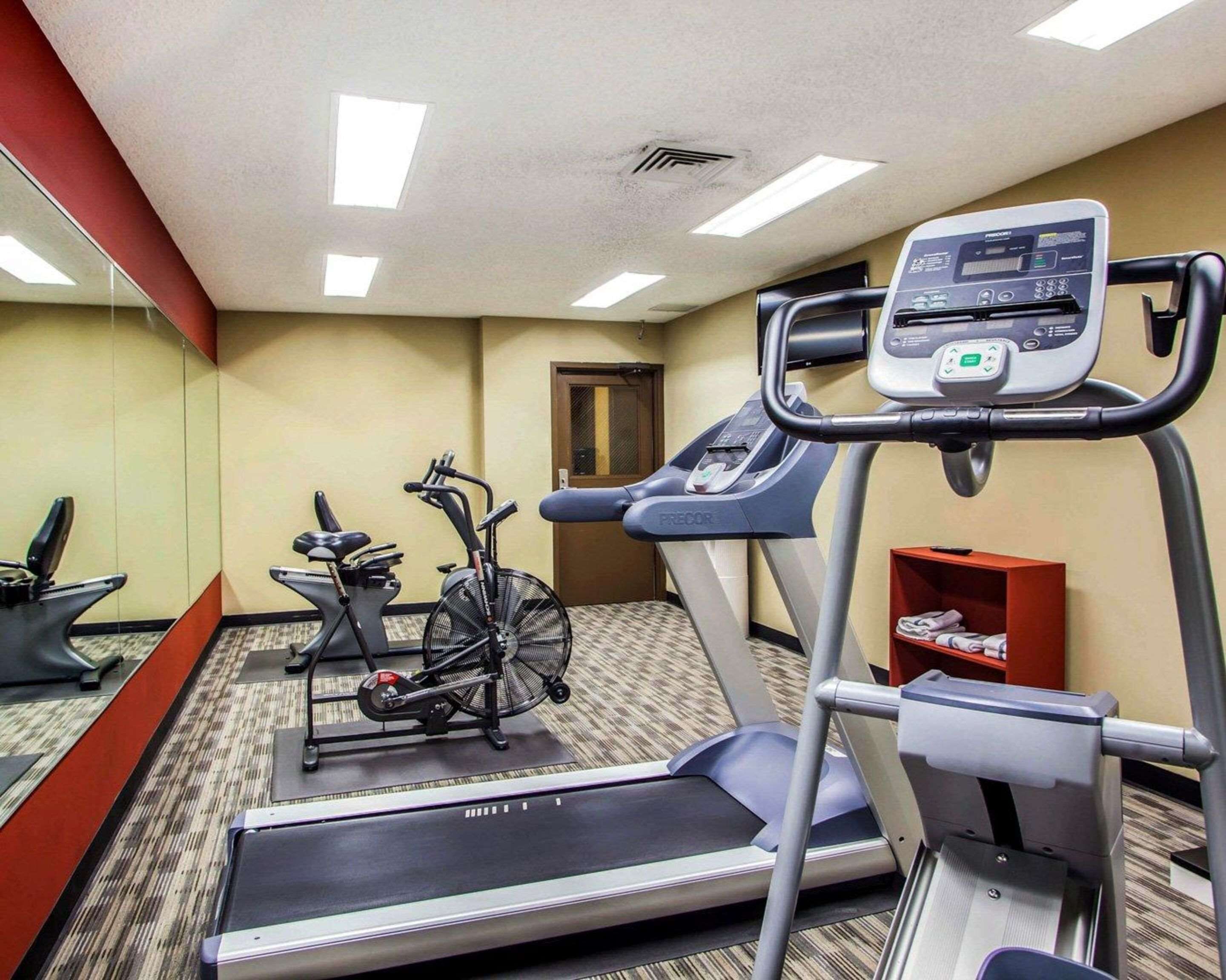 Une salle de sport d’hôtel équipée d’un tapis de course, d’un vélo elliptique et d’un vélo d’appartement.