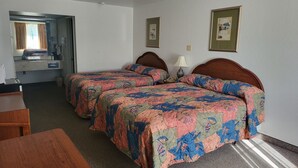 A hotel room with two beds, a desk, a chair, and a small table. - Blue Ribbon Inn and Suites (Sallisaw)