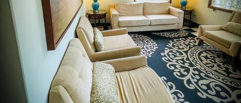 A living room with a beige sofa, a patterned rug, and two lamps.