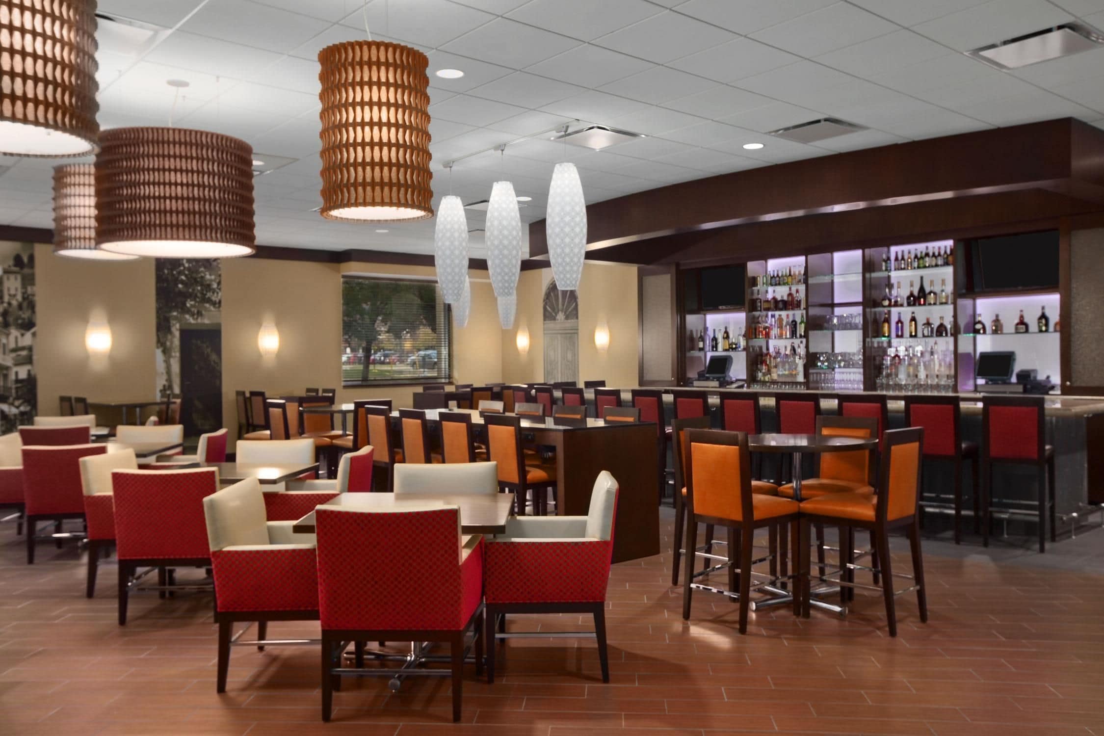 A restaurant with multiple seating areas, including booths and tables, and a bar area with shelves of bottles.