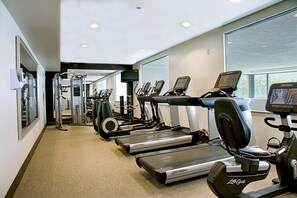 A gym with treadmills, elliptical machines, and weight equipment. - Embassy Suites by Hilton Chicago O'Hare Rosemont (Rosemont)