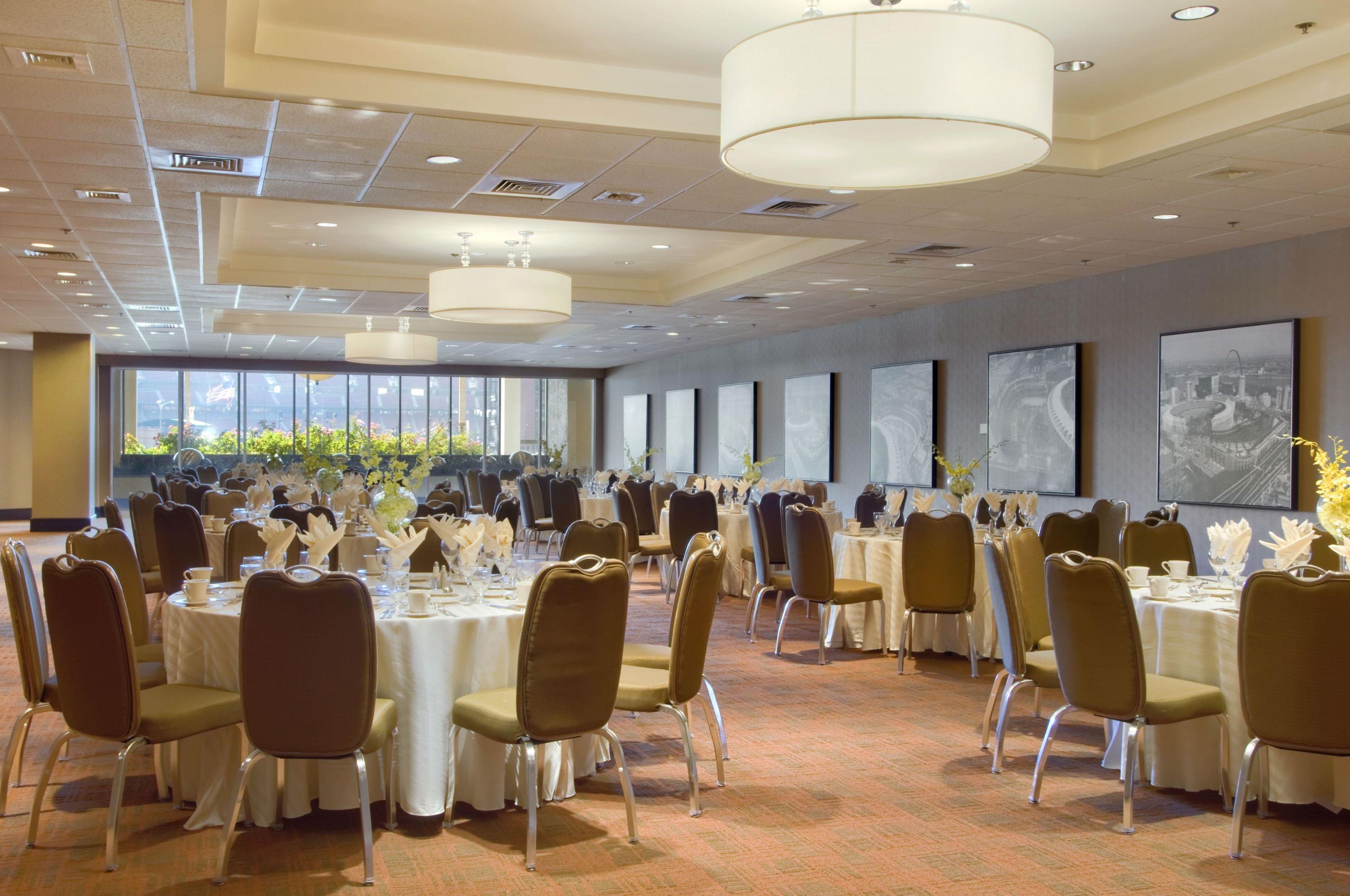 A conference room with round tables, chairs, and a large window with a view.