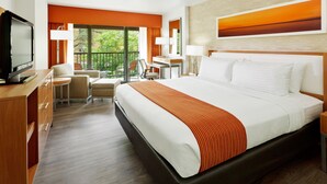 Una habitación de hotel con una cama grande, un escritorio, una silla y un televisor.