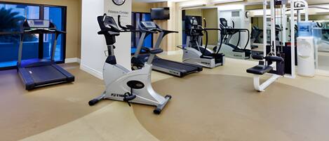 A gym with treadmills, elliptical machines, and weight equipment.