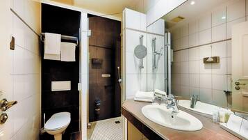 A modern bathroom with a toilet, bidet, and a large mirror.