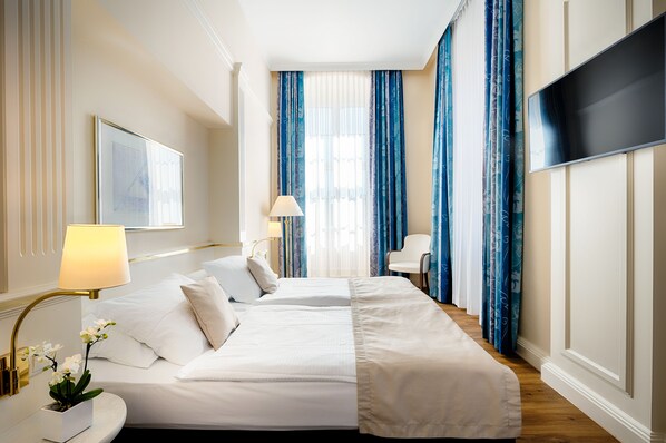 Relax in a serene space with a large bed, flat-screen TV, and comfortable seating area.
