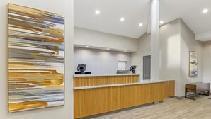 A reception area with a wooden reception desk, a large abstract painting on the wall, and a modern interior design.