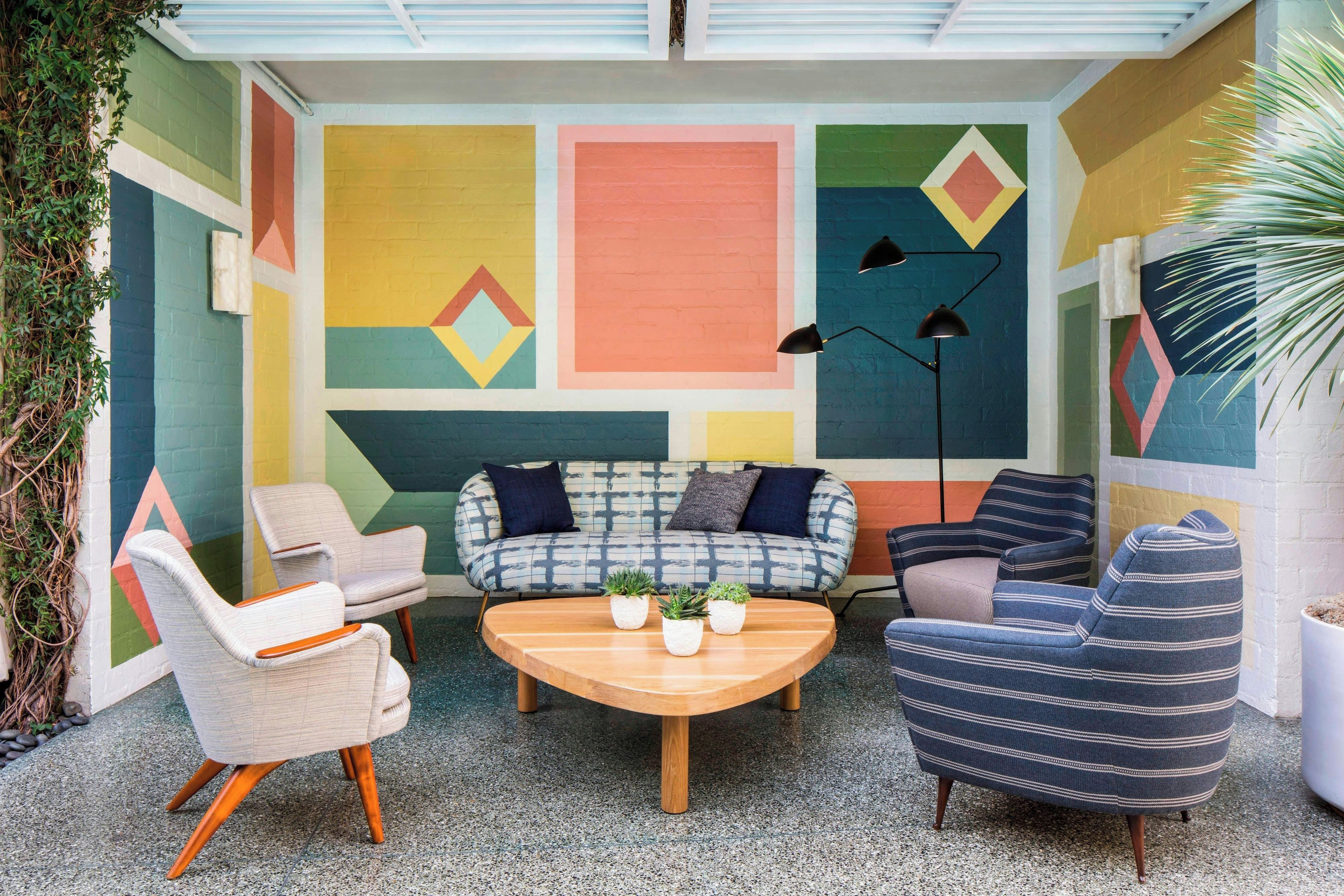 Un espace de détente intérieur, chaleureux, avec un canapé à motifs, des fauteuils et une table basse.