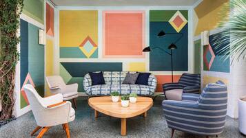 Un espace de détente intérieur, chaleureux, avec un canapé à motifs, des fauteuils et une table basse.