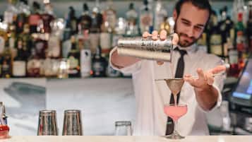 Un bartender sirve una bebida en una copa de martini.