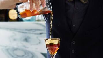 Un camarero sirviendo una bebida en una copa de martini.