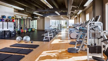 A gym with exercise equipment, mats, and weights.