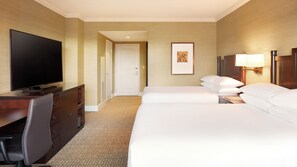 A hotel room with a flat-screen TV, a desk with a chair, two beds, a framed picture on the wall, and a lamp on the nightstand. - Hyatt Regency Bellevue (Bellevue)