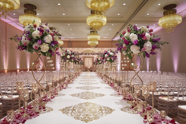Formal events take place in this grand banquet hall with a long table, ornate chandeliers, and elegant floral arrangements.