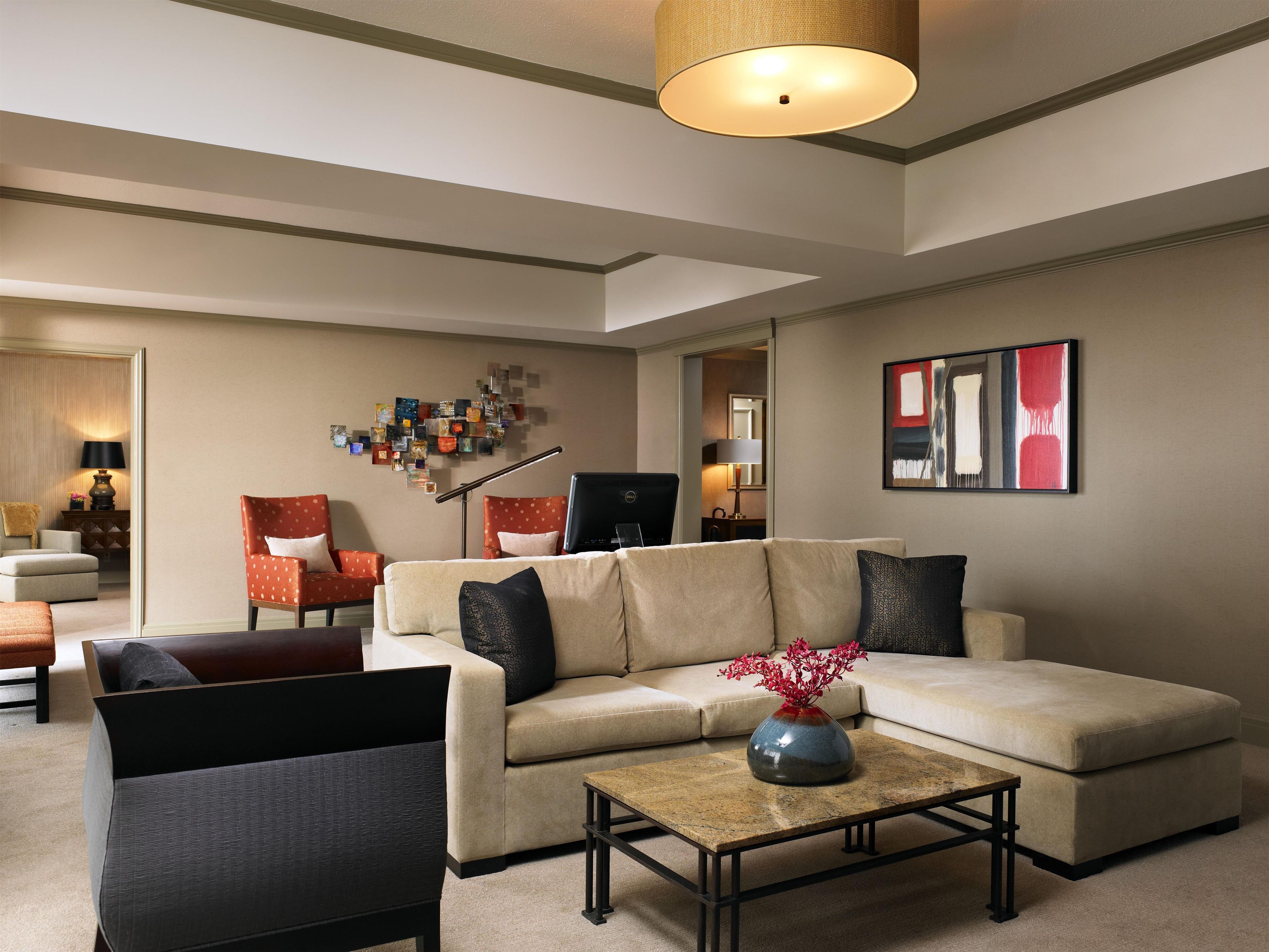 A living room with a sectional sofa, a coffee table, and a wall art piece.