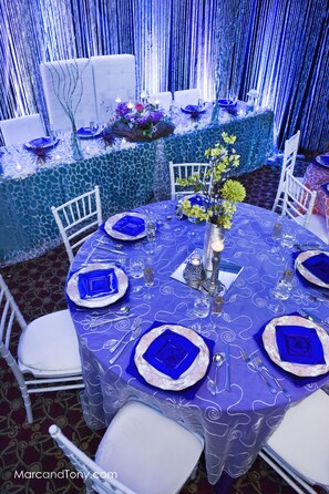 A round table with a blue tablecloth, white chairs, and blue centerpieces. - Crowne Plaza Cleveland Airport by IHG (Middleburg Heights)