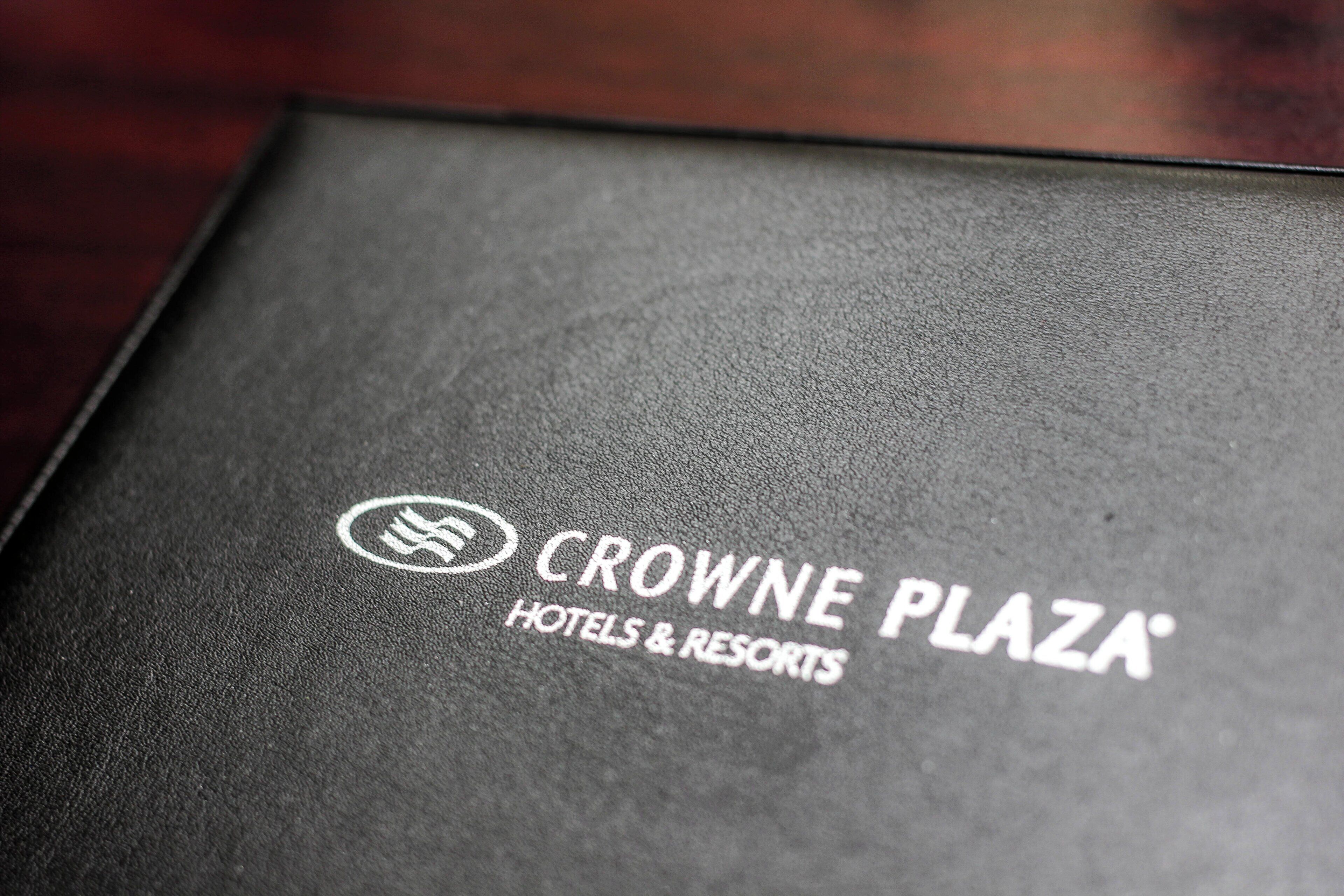 A black brochure for Crowne Plaza Hotels & Resorts with a logo and text.