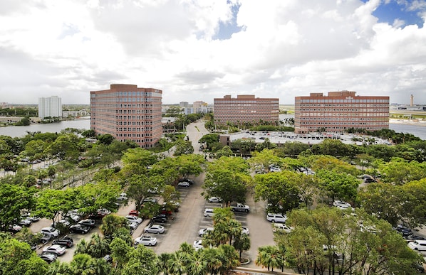 Un parking rempli de voitures, avec une rivière en arrière-plan.