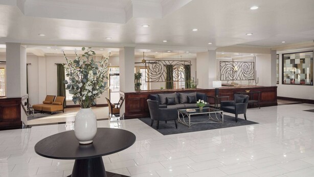 A spacious lobby with a modern design, featuring a reception desk, seating area, and decorative elements.