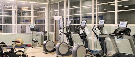 A gym with treadmills, elliptical machines, and stationary bikes.