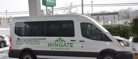 A white van with "Wingate by Wyndham" branding parked at a gas station.