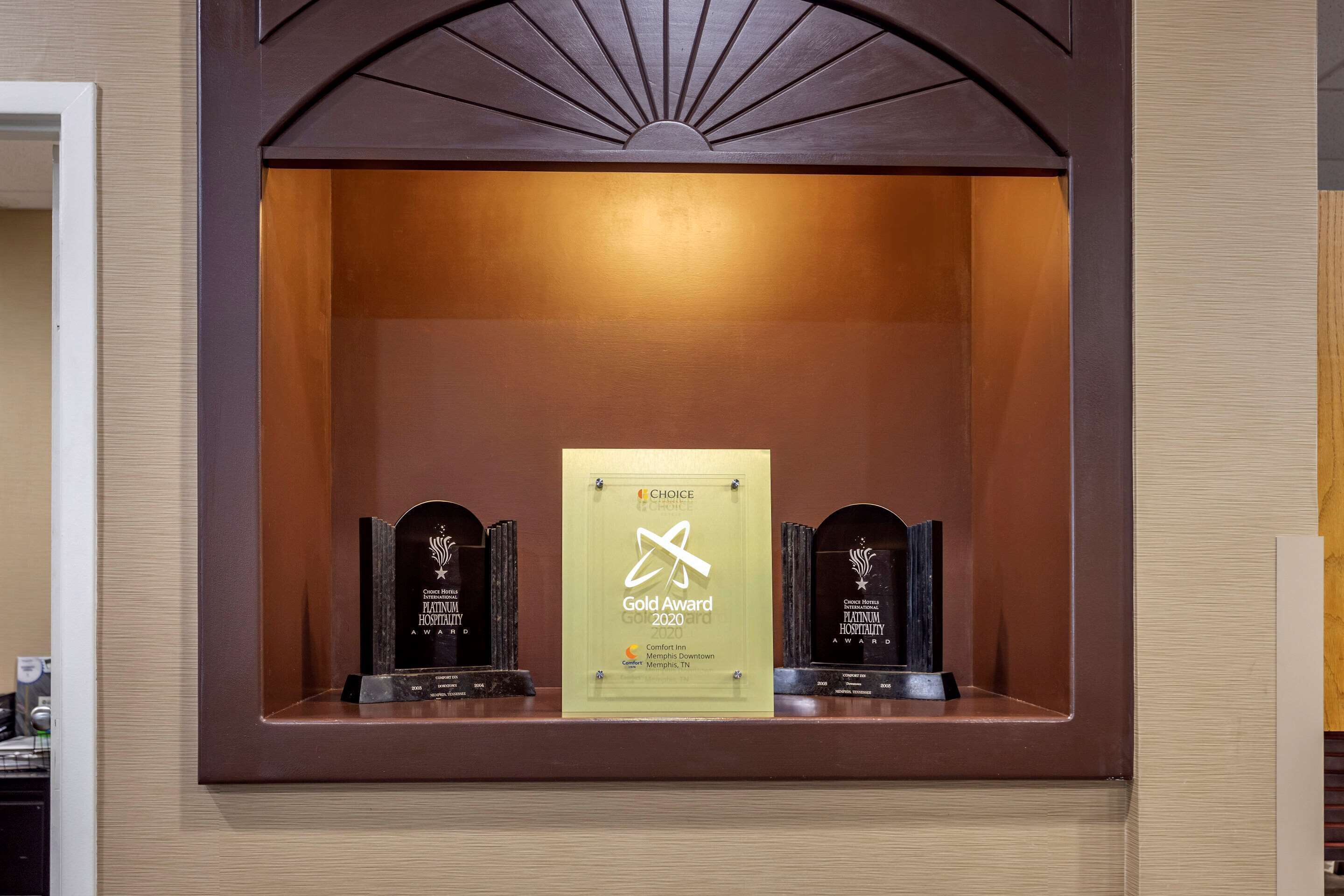 Une vitrine contenant une plaque commémorative du prix « Choice Gold Award 2020 », flanquée de deux plaques plus petites.