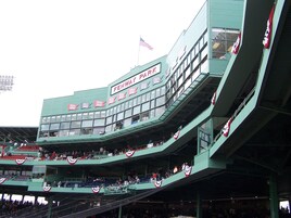 Het Fenway Park stadion met meerdere niveaus van zitplaatsen en een opvallende Amerikaanse vlag.
