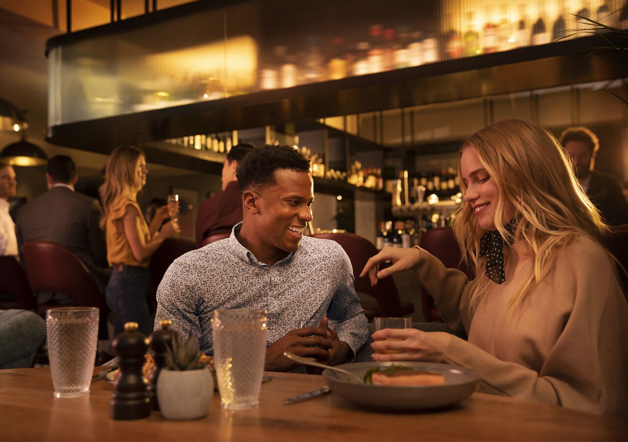 Un espace bar avec un comptoir, des verres et un menu.